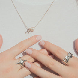 Sisyphus Necklace worn on female model with other jewelry